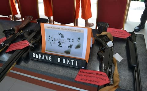 Evidence displayed to the media of weapons allegedly used by four Indonesian men while hunting and killing an orangutan - Credit: AFP