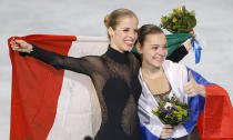 Adelina Sotnikova of Russia, right, and Carolina Kostner of Italy celebrate with their national flags as they pose for photographers following the flower ceremony for the women's free skate figure skating final at the Iceberg Skating Palace during the 2014 Winter Olympics, Thursday, Feb. 20, 2014, in Sochi, Russia. Sotnikova placed first, followed by Kim and Kostner. (AP Photo/Vadim Ghirda)