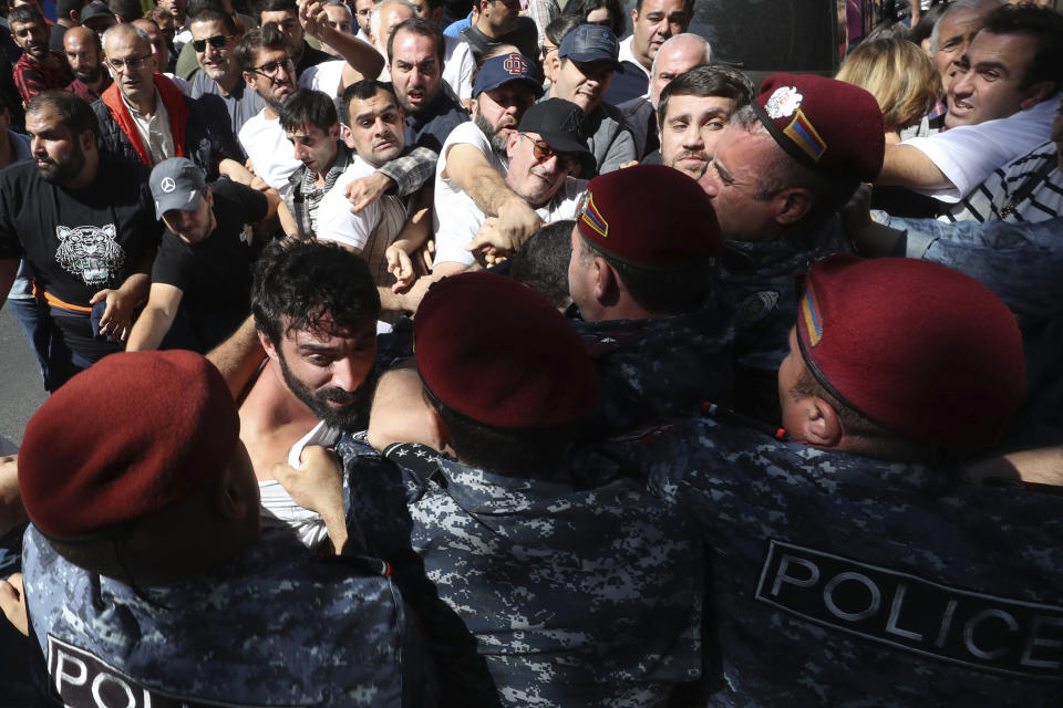 Police officers try to detain demonstrators during a protest against Prime Minister Nikol Pashinyan in Yerevan, Armenia, Friday, Sept. 22, 2023. (Vahram Baghdasaryan/Photolure via AP)