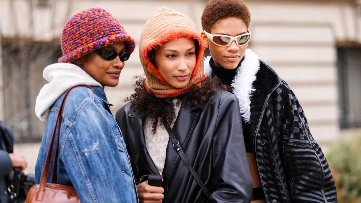 three women wearing winter jackets and warm accessories to illustrate a guide to the best black friday and cyber monday deals of 2023