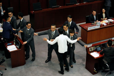 Pro-democracy lawmakers Eddie Chu (in white) and Raymond Chan are blocked by security guards as they try to stop the process of electing council chairman at the Legislative Council in Hong Kong, China October 12, 2016. REUTERS/Bobby Yip