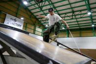 Blind Japanese skateboarder Ryusei Ouchi trains at a skatepark holding a cane, in Tokorozawa