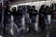 U.S. Homeland Security police officers stand guard as migrants block the Paso del Norte border crossing bridge after a U.S. appeals court blocked the Migrant Protection Protocols (MPP) program, as seen from Ciudad Juarez