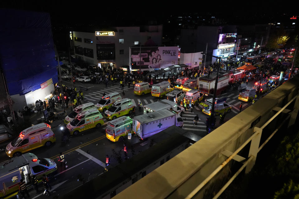 Ambulances and rescue workers arrive at the street near the scene of a crowd surge in Seoul, South Korea, Sunday, Oct. 30, 2022. Witnesses say the nightmarish scene intensified as people performed CPR on the dying and carried limp bodies to ambulances, while dance music pulsed from garish clubs lit in bright neon. Others tried desperately to pull out those who were trapped underneath the crush of people, but failed because too many in the crowd had fallen on top of them. (AP Photo/Lee Jin-man)