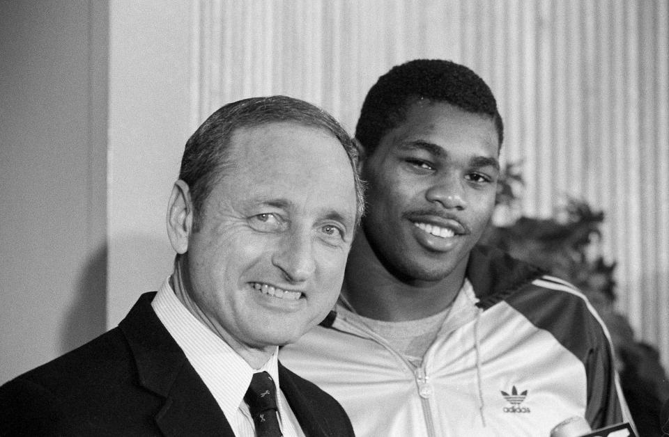 FILE - Georgia running back Herschel Walker, right, brings a smile to the face of his coach Vince Dooley as he announces that he would play football next year at Georgia rather than the USFL, Feb. 8, 1983 in Athens, Ga. Vince Dooley, the football coach who carried himself like a professor and guided Georgia for a quarter-century of success that included the 1980 national championship, died Friday, Oct. 28, 2022. He was 90. (AP Photo/Joe Holloway Jr., File)