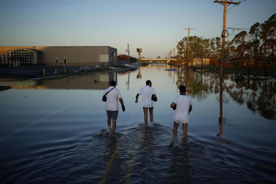 PHOTO: People walk down a flooded street after Hurricane Delta made landfall in Lake Charles, La., on Oct. 10, 2020.  (Luke Sharrett/Bloomberg via Getty Images)