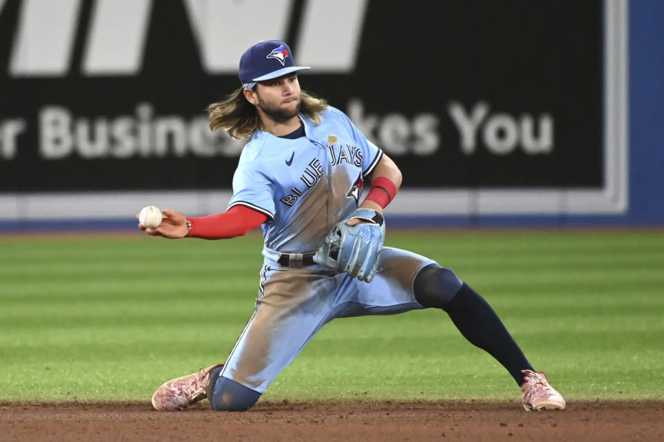 Toronto Blue Jays' Bo Bichette throws out Houston Astros' Jordan Alvarez at second base in the seventh inning of a baseball game in Toronto, Saturday, April 30, 2022. (Jon Blacker/The Canadian Press via AP)