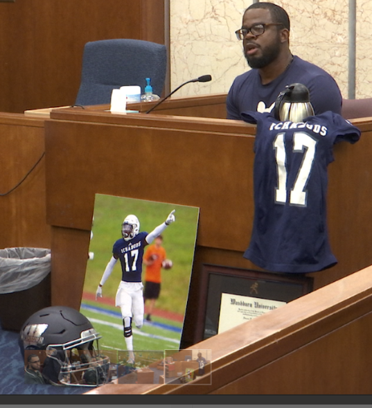 Navarro Simmons testifies at Friday's sentencing hearing for the man who killed his son, Dwane Simmons, while accompanied by mementos of his son's time as a football player at Washburn University.