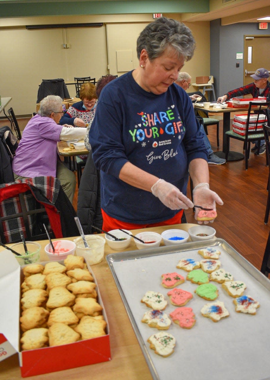 Sue Felder of Bellevue and her husband have joined several of the bus trips hosted by Golden Threads. Here, she decorates cookies for Golden Threads Operation Cookie Drop.