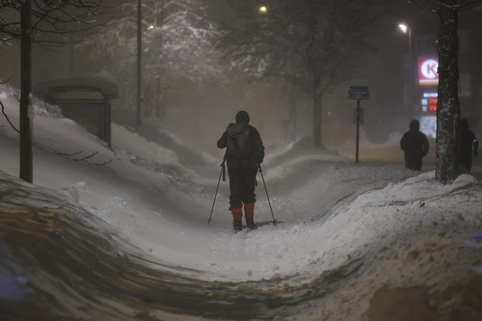 A resident uses skis to get to work in downtown Kristiansand, Norway, Wednesday, Jan. 3, 2024, due to the heavy snowfall the last couple of days. (Tor Erik Schroder/NTB via AP)