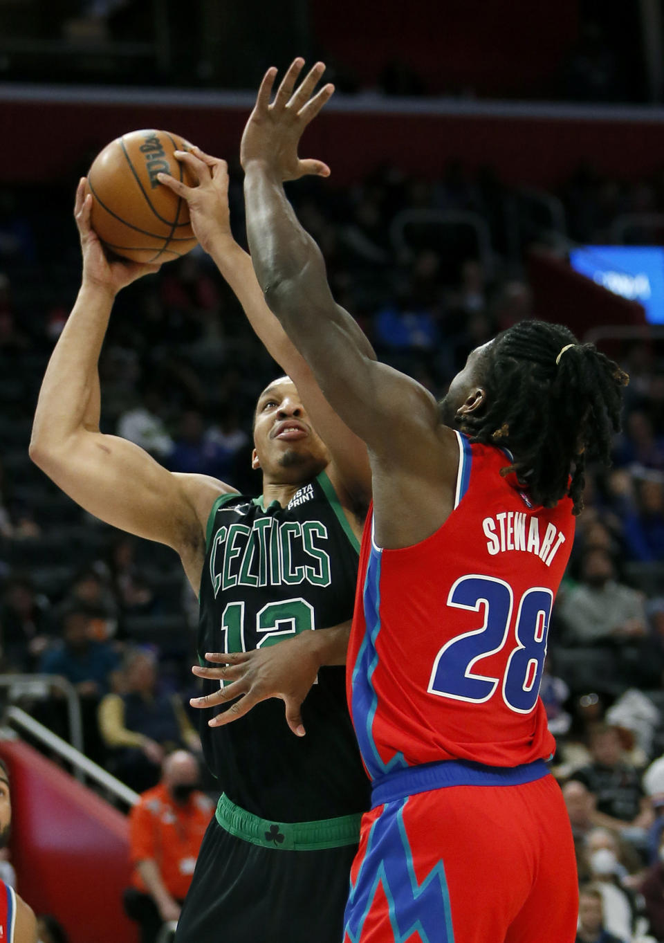 Boston Celtics forward Grant Williams, left, takes a shot against Detroit Pistons center Isaiah Stewart (28) during the first half of an NBA basketball game Saturday, Feb. 26, 2022, in Detroit. (AP Photo/Duane Burleson)