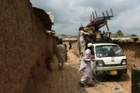 Afghan refugees and Pakistani tribal people shift their belongings during an operation to demolish their poverty-stricken neighbourhood in Islamabad on July 31, 2015