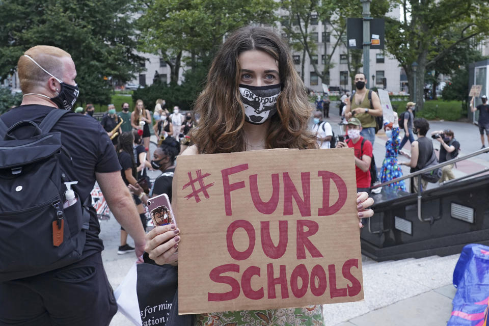 A protester holds a placard that says Fund Our Schools during a demonstration in New York City earlier this month. Several groups, including the United Federation of Teachers, gathered on the National Day of Resistance to protest against reopening of schools as well as for removing police from schools. (Photo: Ron Adar/SOPA Images/LightRocket via Getty Images)