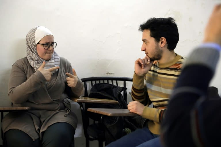 Syrian bio-medical engineer and sign language teacher Wisal al-Ahdab (L) communicates using sign language with 21-year-old deaf student Riyad Hommos during a class at the EEMAA association, an NGO centre in Damascus' Midan district