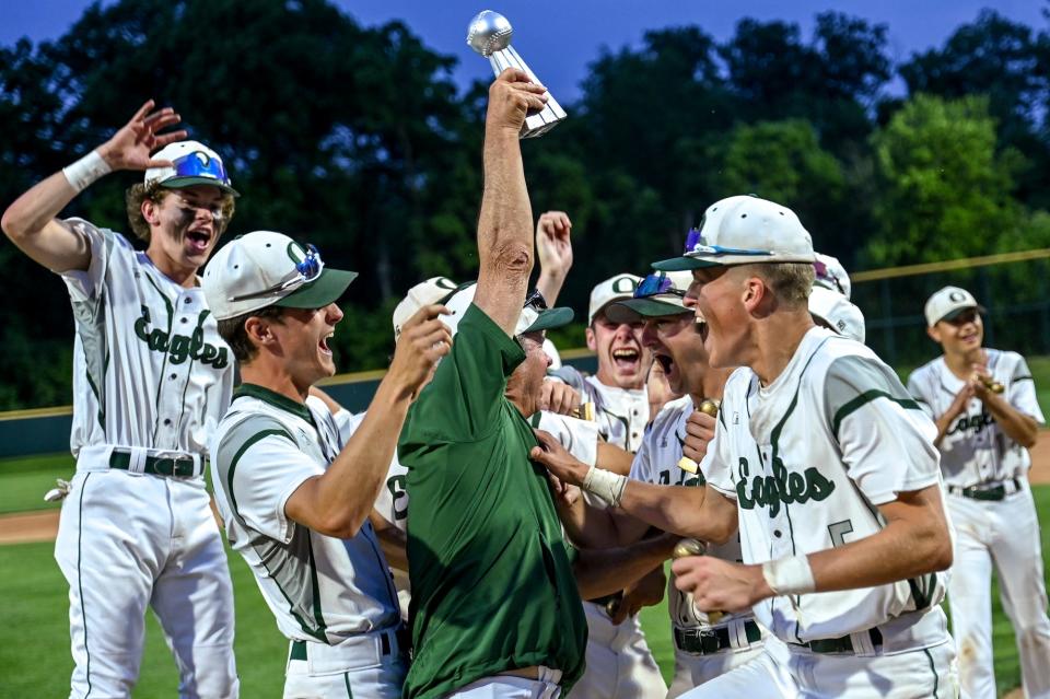 Olivet head coach Bill Whitely, center, hoists the Diamond Classic championship trophy as the team celebrates after beating Grand Ledge on Monday, June 5, 2023, at McLane Stadium on the Michigan State University campus in East Lansing.