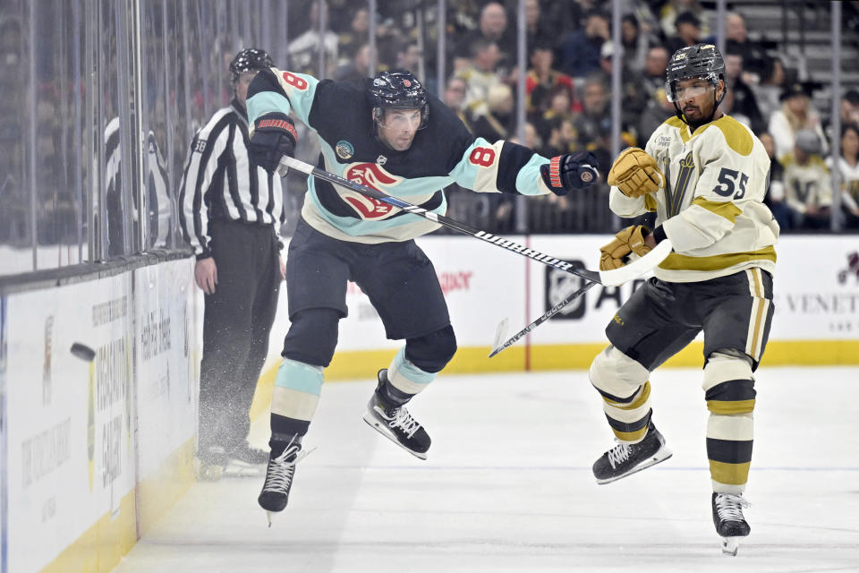 Seattle Kraken defenseman Brian Dumoulin (8) and Vegas Golden Knights right wing Keegan Kolesar (55) chase the puck during the second period of an NHL hockey game Thursday, March 21, 2024, in Las Vegas. (AP Photo/David Becker)