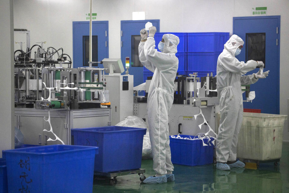 In this April 12, 2020, photo, workers inspect masks at a mask factory production line of the Wuhan Zonsen Medical Products Co. Ltd. in Wuhan in central China Hubei province. The United States, Japan and France are prodding their companies to rely less on China to make the world’s smartphones, drugs and other products. But even after the coronavirus derailed global trade, few are willing to give up access to its skilled workers, vast market and efficient suppliers by moving factories closer to home.(AP Photo/Ng Han Guan)