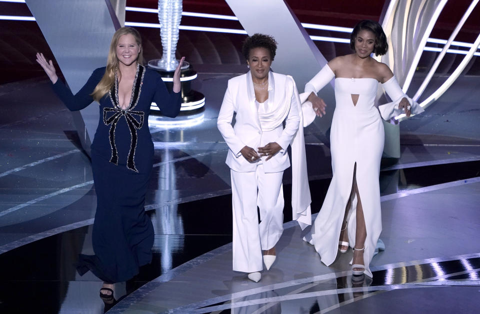 Las conductoras Amy Schumer, Wanda Sykes y Regina Hall, de izquierda a derecha, durante la ceremonia de los premios Oscar el domingo 27 de marzo de 2022 en el Teatro Dolby en Los Ángeles. (Foto AP/Chris Pizzello)