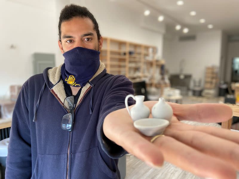 Co-owner of Mouse Ceramic Studio, Pedro Ramirez, poses with wheel-thrown pottery inside his closed studio in Brooklyn, New York