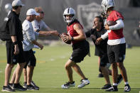 Las Vegas Raiders quarterback Derek Carr, center, takes part in a drill during an NFL football practice Tuesday, June 15, 2021, in Henderson, Nev. (AP Photo/John Locher)