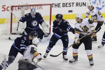 May 20, 2018; Winnipeg, Manitoba, CAN; Vegas Golden Knights right wing Ryan Reaves (75) tips the puck to score a goal past Winnipeg Jets goaltender Connor Hellebuyck (37) in the second period in game five of the Western Conference Final of the 2018 Stanley Cup Playoffs at Bell MTS Centre. Mandatory Credit: James Carey Lauder-USA TODAY Sports