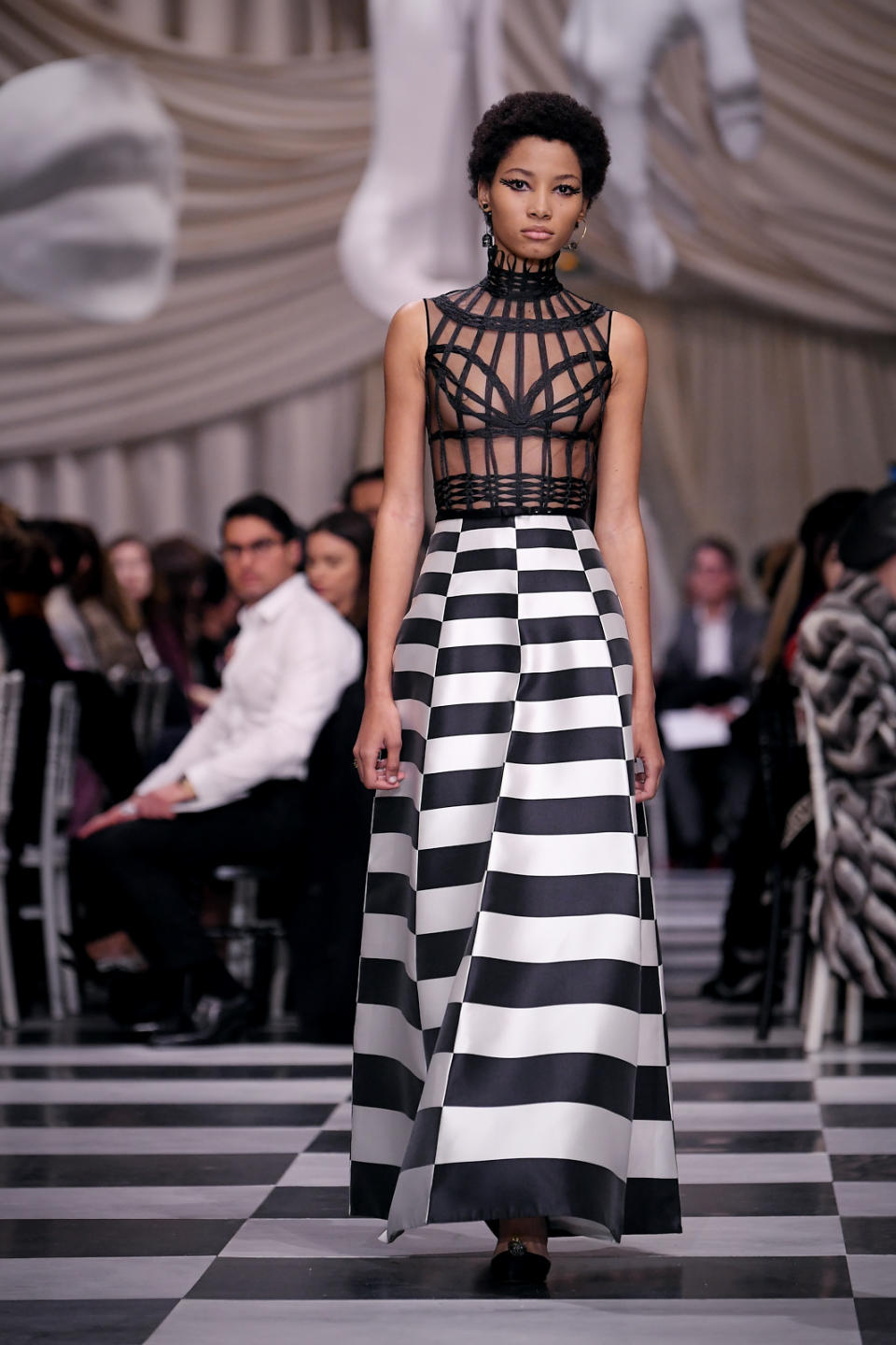 <p>Model wears a black caged bodice and black and white checkered skirt from the Dior Haute Couture SS18 collection. (Photo: Getty) </p>