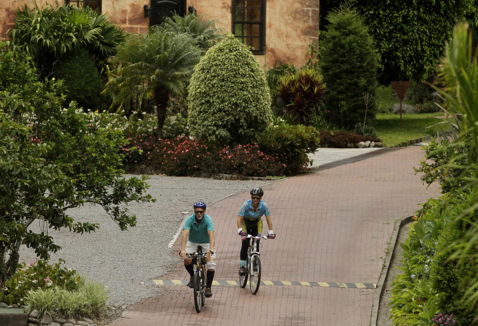 This May 28, 2013 photo shows retired couple bicycling in Valle Escondido, a residential community in Boquete, west from Panama City. Panama has become a hot spot for American retirees. They come for the natural beauty, the weather and, perhaps more important, the low cost of living. (AP Photo/Arnulfo Franco)