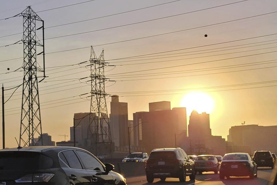 Vehicles travel near high power transmission towers in downtown Los Angeles, Tuesday, Sept. 6, 2022. As California stretched into its second week of excessive heat, the California Independent System Operator, the entity that oversees the state's electrical grid, issued a Stage 3 alert allowing it to draw on emergency power sources. The alert is one step below actually ordering rotating power outages. CAISO said the peak electricity demand on Tuesday hit 52,061 megawatts, far above the previous high of 50,270 megawatts set on July 24, 2006. (AP Photo/Damian Dovarganes)