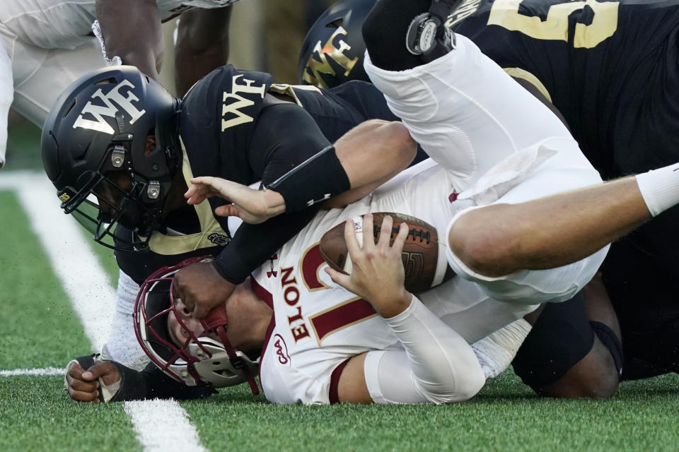 Elon quarterback Matthew Downing, bottom, is sacked by Wake Forest linebacker Jacob Roberts during the first half of an NCAA college football game in Winston-Salem, N.C., Thursday, Aug. 31, 2023. (AP Photo/Chuck Burton)