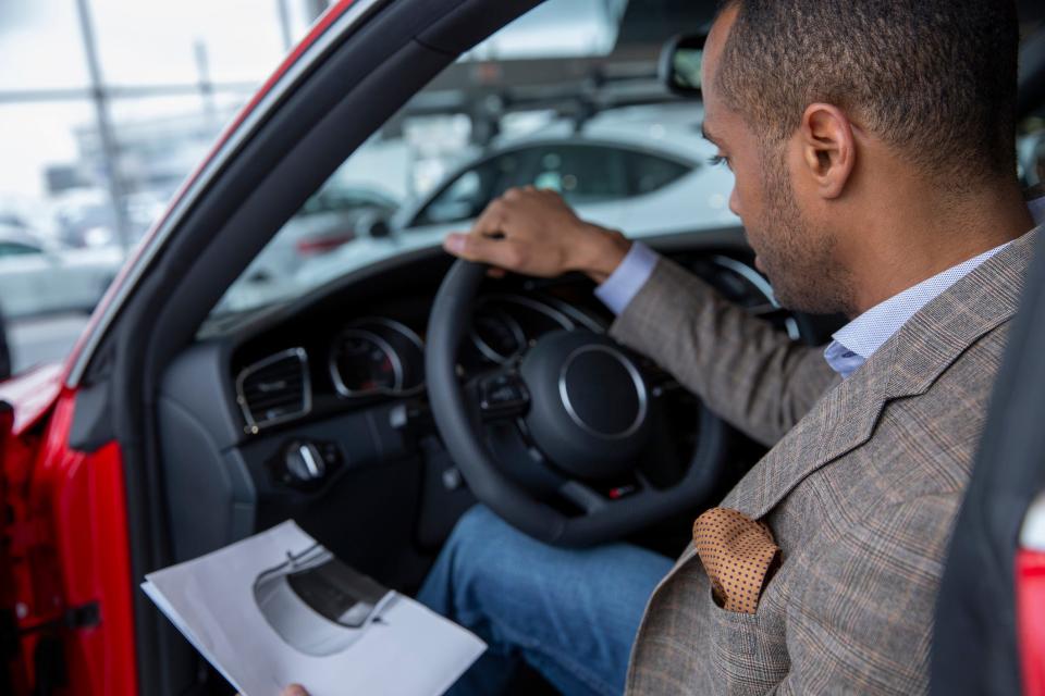 man sitting behind the wheel of a car