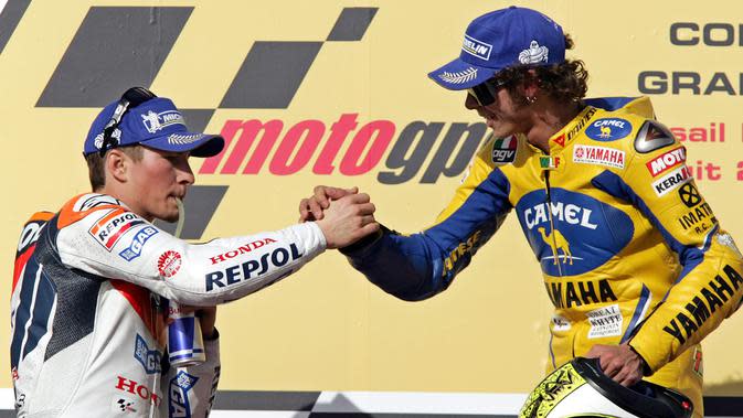 Nicky Hayden (kiri) dari tim America of Honda berjabat tangan dengan Valentino Rossi dari tim Yamaha Italia saat berada di podium usai laga Qatar MotorGP di Sirkuit Losail, di Doha, Qatar, Sabtu (8/4/2006). (AP Photo / Kamran Jebreili)