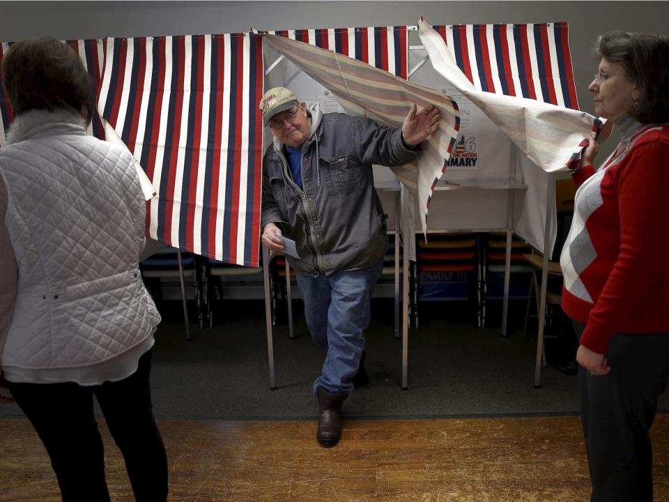 A voter exits a voting booth after filling out his ballot in the U.S. presidential primary election in the village of Groveton, New Hampshire