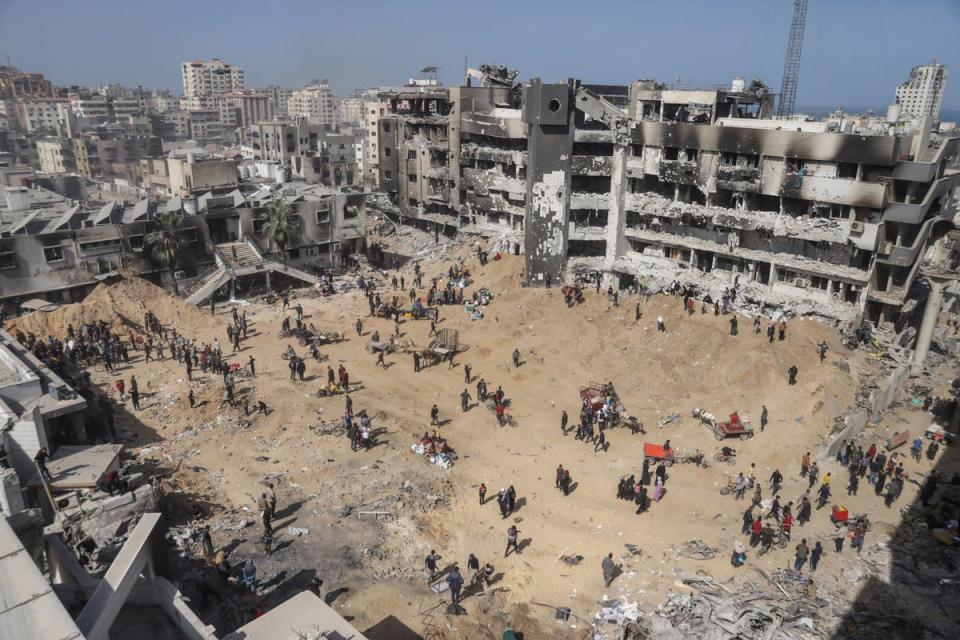 Palestinians walk through the destruction left by the Israeli air and ground offensive on the Gaza Strip near Shifa Hospital in Gaza City (AP)