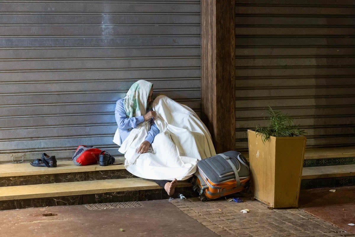 Residents take shelter outside shops in Marrakech (AFP)