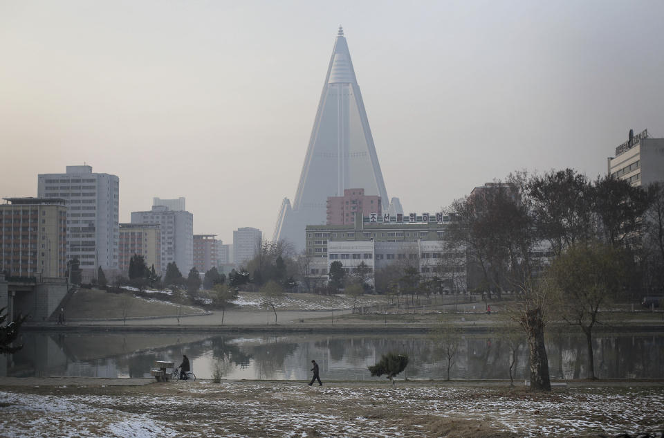FILE - In this Nov. 28, 2015, file photo, a man is dwarfed against the 105-storey Ryuryong hotel as he walks along the Pothong River on Saturday, Nov. 28, 2015, in Pyongyang, North Korea. With a U.S. soldier crossing the border into North Korea at the border town of Panmunjom on Tuesday, July 18, 2023, and in custody this week, talk turns to the nation itself — a country that is known for its suspicion of outsiders but also rejects frequent descriptions of it as reclusive. (AP Photo/Wong Maye-E, File)