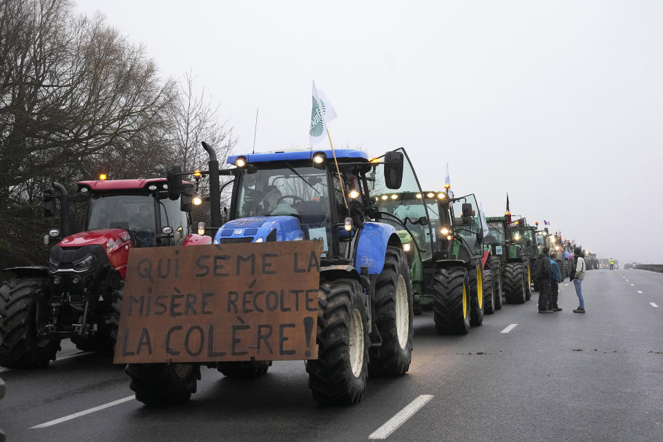 Farmers prepare to lift a blockade, Friday, Feb. 2, 2024 in Les Ulis, south of Paris. France's two major farmers unions announced they would lift country-wide blockades Thursday, shortly after the prime minister introduced new measures aimed at protecting their livelihoods that they described as "tangible progress." (AP Photo/Michel Euler)