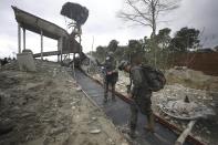 National Police stand at an illegal gold mining operation as they work to destroy it as part of the Armed Forces' "Operation Guamuez III" in Magui Payan, Colombia, Tuesday, April 20, 2021. Illegal gold mining is common in Colombia, especially wildcat mines in poverty-stricken areas dominated by criminal gangs with little state presence. (AP Photo/Fernando Vergara)