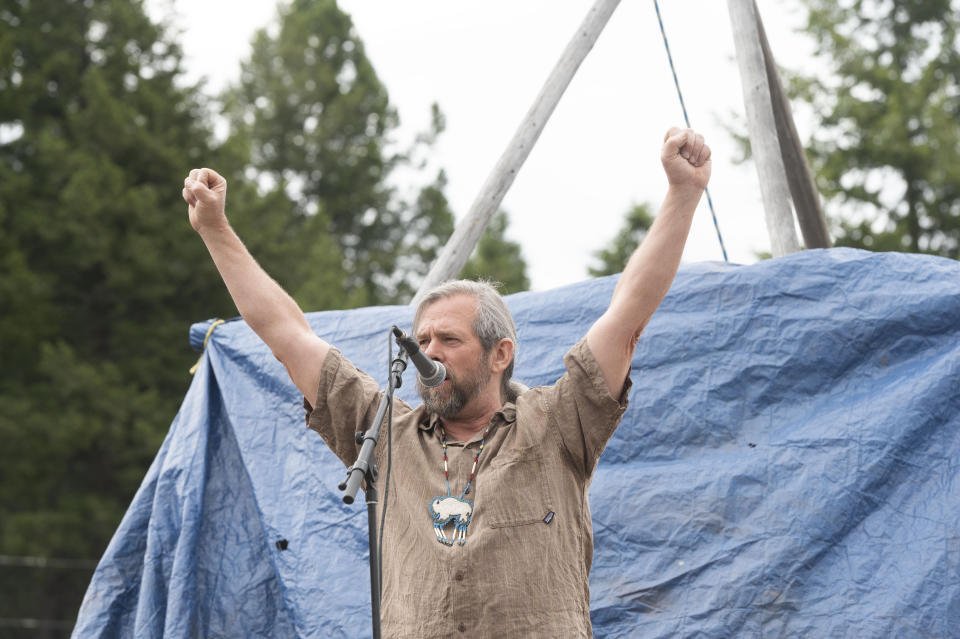 Mike Mease, co-founder of the Buffalo Field Campaign, raises his arms while concluding a speech during a naming ceremony for a recently born white buffalo calf in West Yellowstone, Mont., Wednesday, June 26, 2024. The reported birth of the calf in Yellowstone National Park fulfills a Lakota prophecy that portends better times. (AP Photo/Sam Wilson)