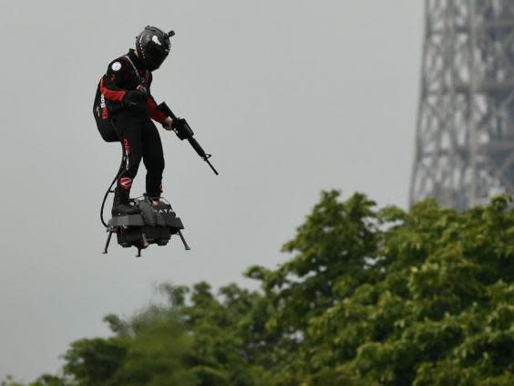 Zapata CEO Franky Zapata flies a jet-powered hoverboard or 'Flyboard prior to the Bastille Day military parade down the Champs-Elysees avenue in Paris on 14 July, 2019 (AFP/Getty Images)