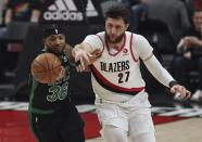 Boston Celtics guard Marcus Smart, left, and Portland Trail Blazers center Jusuf Nurkic, right, battle for a loose ball during the first half of an NBA basketball game in Portland, Ore., Saturday, Dec. 4, 2021. (AP Photo/Steve Dipaola)