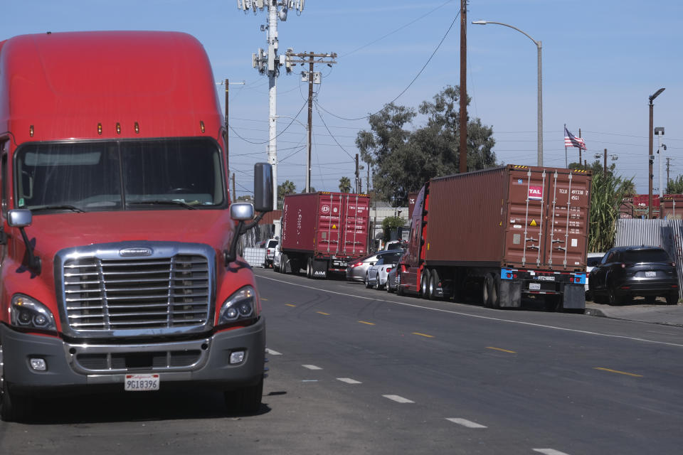 Parked cargo container trucks are seen in a street, Wednesday, Oct. 20, 2021 in Wilmington, Calif. California Gov. Gavin Newsom on Wednesday issued an order that aims to ease bottlenecks at the ports of Los Angeles and Long Beach that have spilled over into neighborhoods where cargo trucks are clogging residential streets. (AP Photo/Ringo H.W. Chiu)