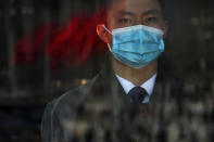 A soldier dressed as an usher stands guard at an entrance door of the Great Hall of the People during the second plenary session of the National People's Congress (NPC) in Beijing, Friday, March 8, 2024. (AP Photo/Andy Wong)