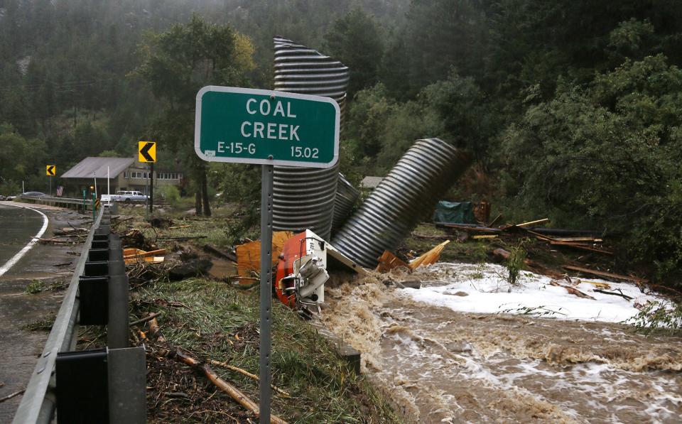 Culverts and a boat are piled up after a flash flood in Coal Creek destroyed bridges near Golden