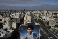 A painter works on a mural of Diego Maradona by artist Martin Ron in Buenos Aires, Argentina, Tuesday, Oct. 18, 2022. The mural is expected to be finished on Oct.30, the birthday of the late soccer star. (AP Photo/Natacha Pisarenko)