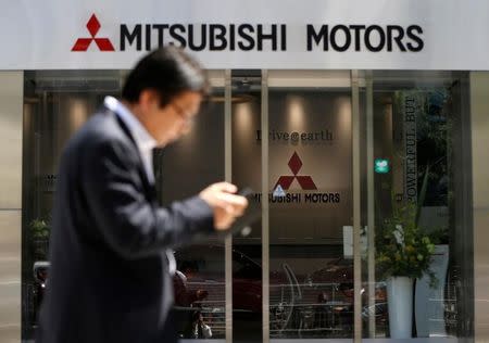 A man walks in front of an entrance of Mitsubishi Motors Corp's headquarters in Tokyo, Japan, May 13, 2016. REUTERS/Issei Kato