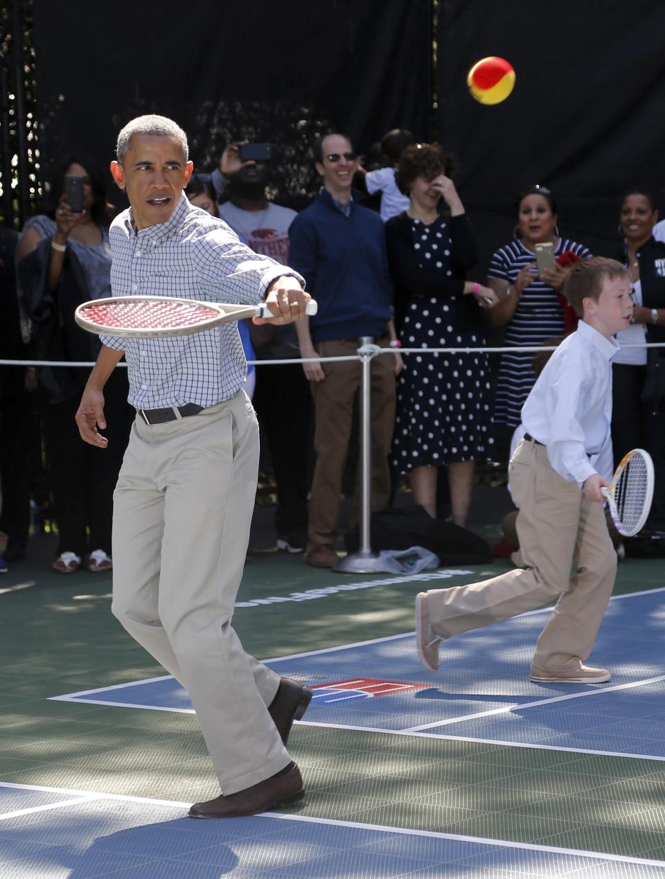 U.S. President Barack Obama plays tennis with kids, one of the activities at the annual Easter Egg Roll at the White House in Washington April 6, 2015. REUTERS/Jonathan Ernst