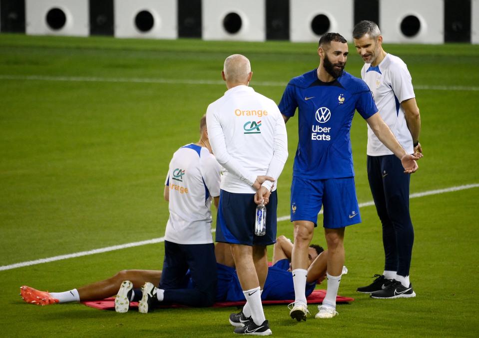 France's defender Raphael Varane (C bottom) speaks with France's forward Karim Benzema (2nd R) at the end of a training session at the Jassim-bin-Hamad Stadium in Doha on November 17, 2022, ahead of the Qatar 2022 World Cup football tournament. (Photo by FRANCK FIFE / AFP) (Photo by FRANCK FIFE/AFP via Getty Images)