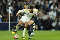 Real Madrid's Jude Bellingham, left, is challenged by Manchester City's Rodrigo during the Champions League quarterfinal first leg soccer match between Real Madrid and Manchester City at the Santiago Bernabeu stadium in Madrid, Spain, Tuesday, April 9, 2024. (AP Photo/Jose Breton)