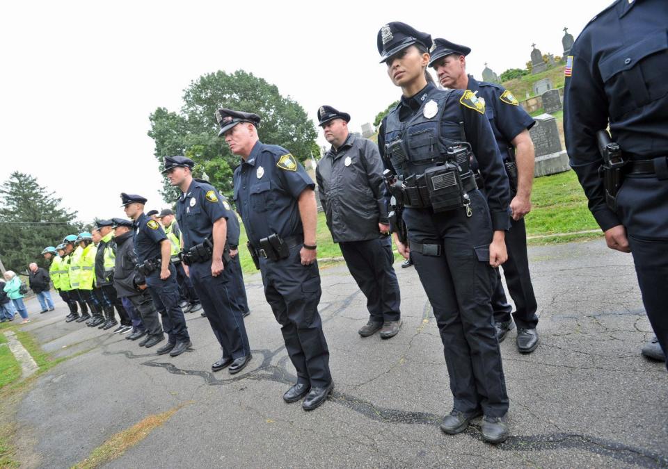 Quincy police officers stand at attention as they honor their late comrade, Alfred Hollis, during the dedication of a headstone at St. Mary's Cemetery in Quincy on Saturday, Oct. 1, 2022. Hollis was killed in the line of duty in 1927.