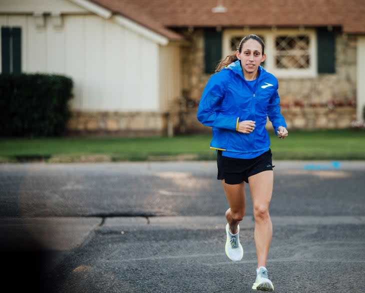 Des Linden running on a street in a blue Brooks jacket